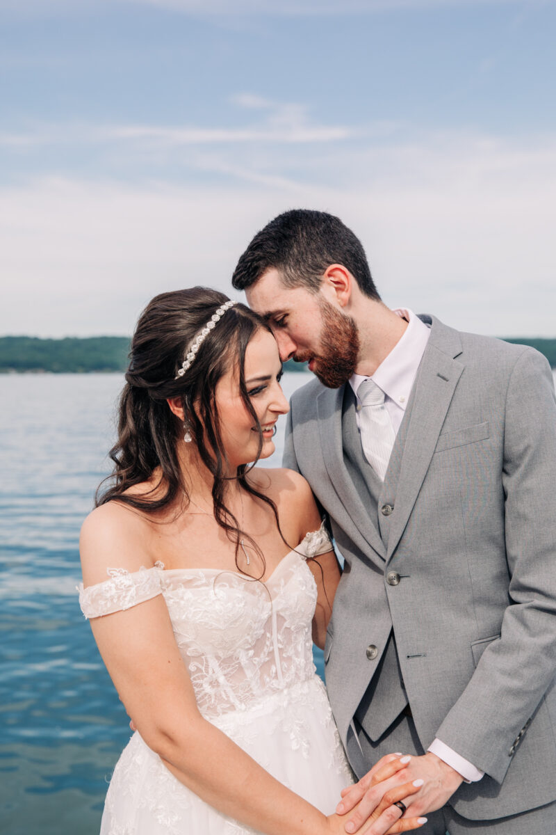 bride-and-groom-stand-on-cayuga-lake-in-the-finger-lakes-region-NY