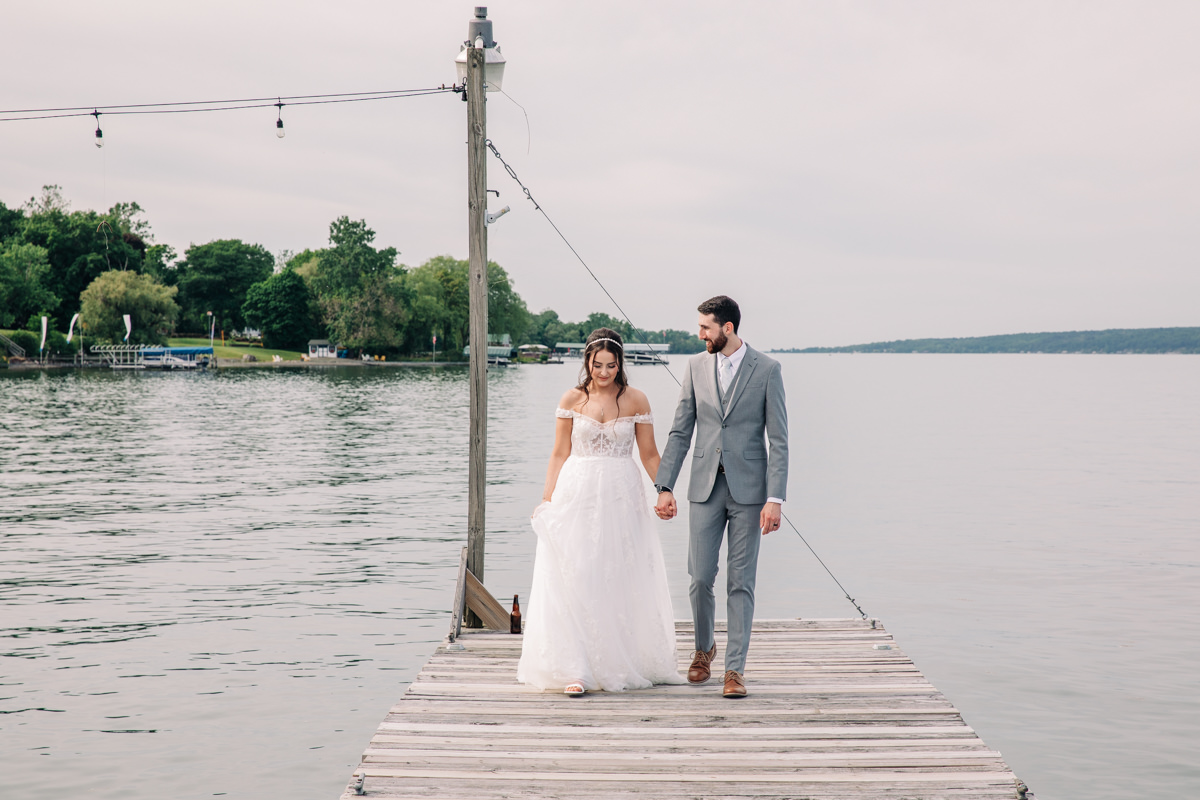 bride-and-groom-stand-on-cayuga-lake-in-the-finger-lakes-region-NY